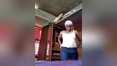 Indian brunette in lingerie and a sexy outfit in the bedroom