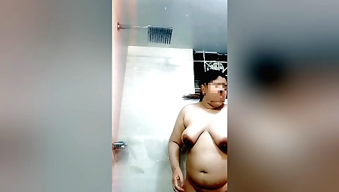 Busty brunette in a sexy bikini shows her body in the shower